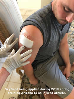 Baseball player being treated for spring training injury by OxyBand CEO